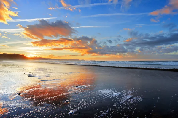 Plage au coucher du soleil avec de beaux nuages — Photo