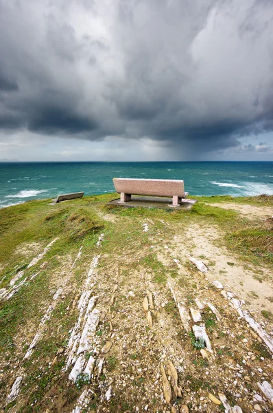 Bancs près de la mer avec nuages orageux — Photo