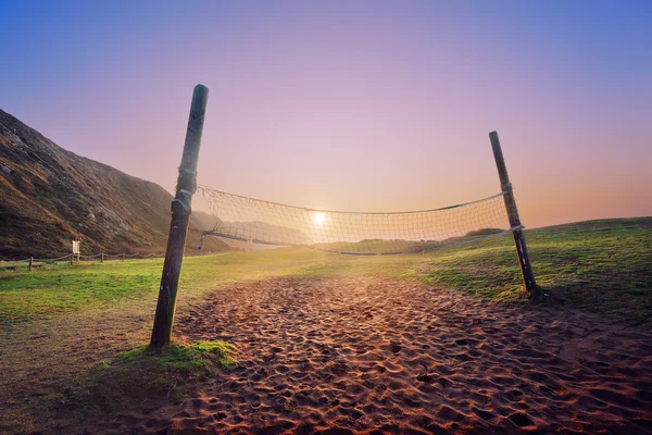 Volleyboll netto på stranden vid solnedgången — Stockfoto