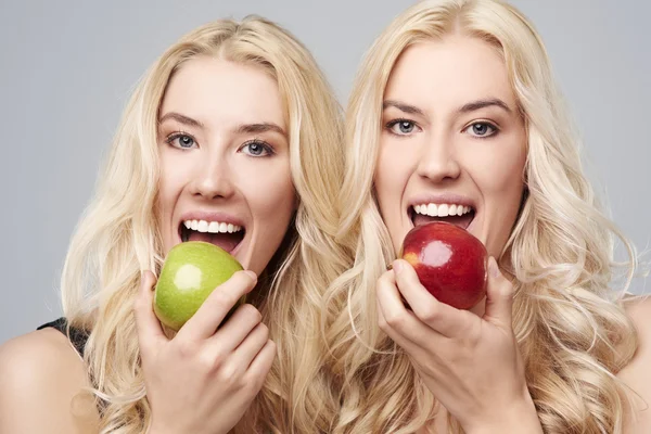 Twins eating apples — Stock Photo, Image