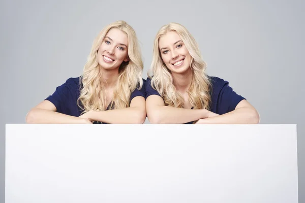 Dvojčata s prázdnou billboard — Stock fotografie