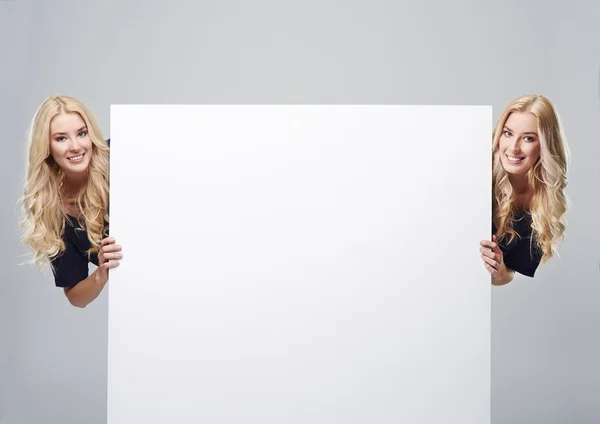 Twins on the both sides of placard — Stock Photo, Image