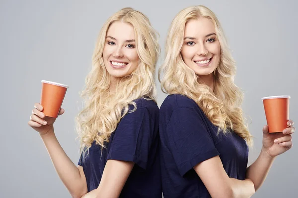 Girls with cups standing back to back — Stock Photo, Image