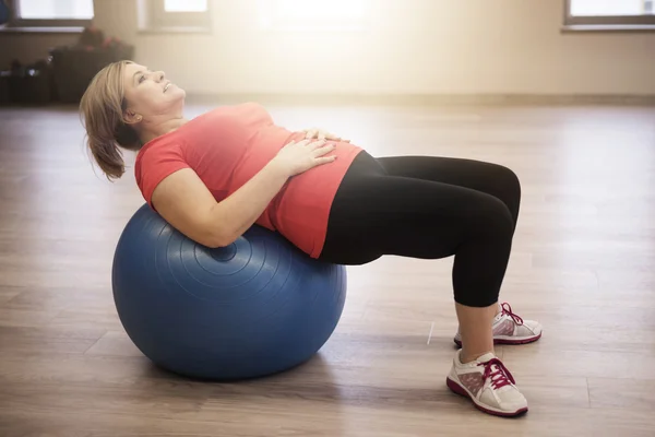 Rijpe vrouw uit te werken in de sportschool — Stockfoto