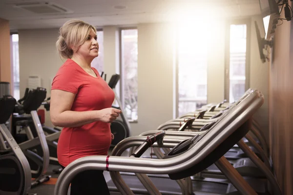 Femme mûre courant à la salle de gym — Photo