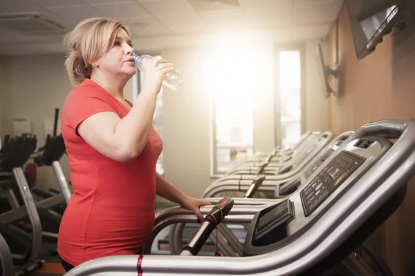 Frau trinkt Wasser während des Laufens — Stockfoto