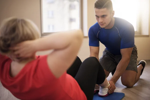 Mulher madura exercitando com personal trainer — Fotografia de Stock