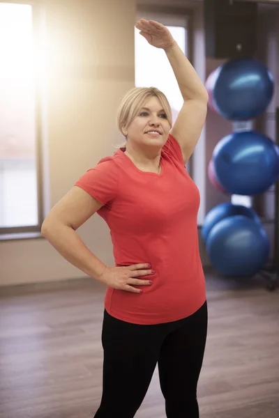 Mujer madura estirándose en el gimnasio — Foto de Stock