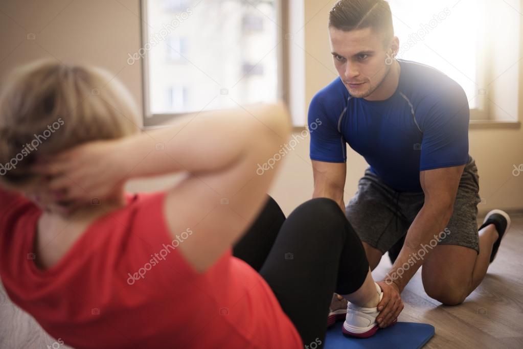 Mature Woman exercising with personal trainer