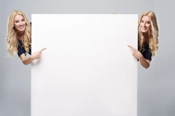 Girls pointing at blank placard — Stock Photo, Image