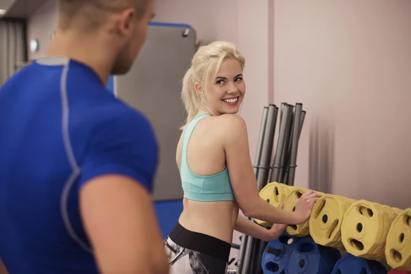 Kvinna och en personlig tränare på gym — Stockfoto