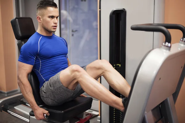 Adam bacak basın makinede egzersiz — Stok fotoğraf