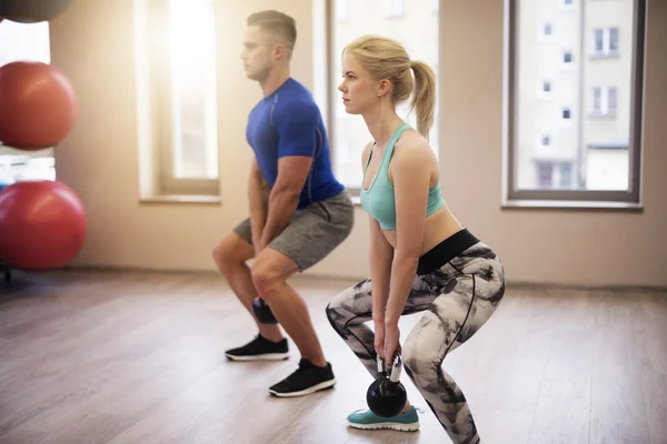 Couple focused on workout with kettles — Stock Photo, Image