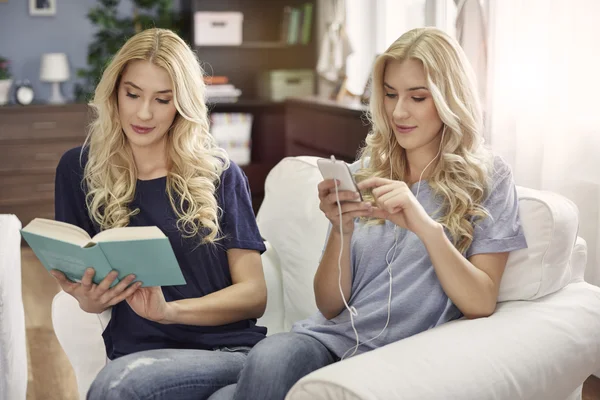 Kitap okuma ve akıllı telefon kullanarak ikiz — Stok fotoğraf