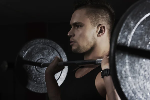 Focused man lifting heavy barbell — Stock Photo, Image