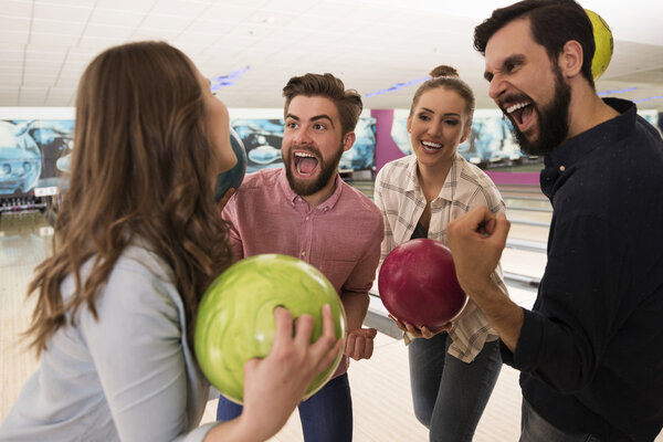 Friends playing bowling game 