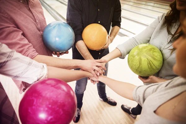 Amigos de pie con bolas de bolos —  Fotos de Stock