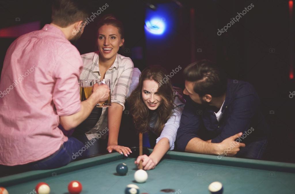 Friends playing pool game — Stock Photo © gpointstudio 106172620
