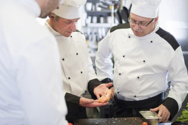 Üç şefler taze balık tartışıyor 