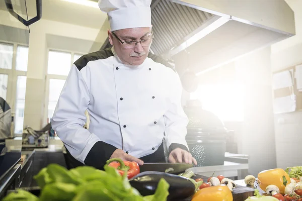 Volwassen chef-kok hakken verse groenten — Stockfoto