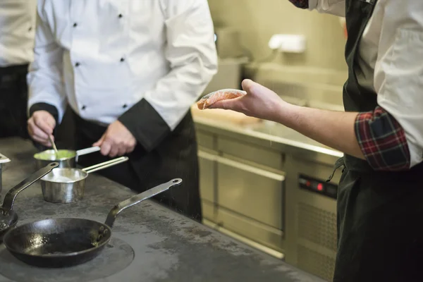 Cocinas trabajando al lado del horno — Foto de Stock