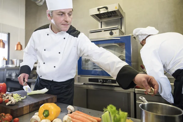 Chef inserindo legumes na panela da cozinha — Fotografia de Stock