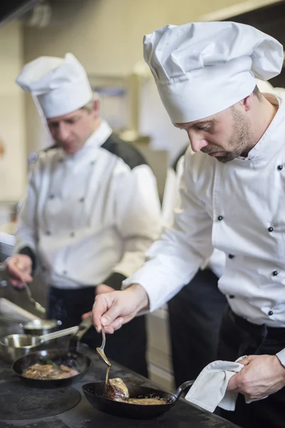 Chef préparant des aliments sur une poêle — Photo