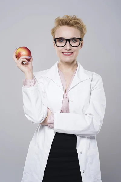 Female doctor holding apple — Stock Photo, Image