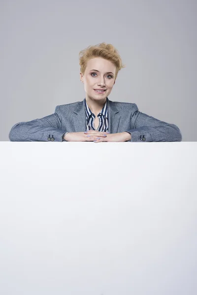 Woman leaning on a big placard — Stock Photo, Image