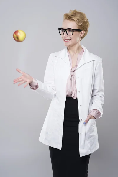 Médico feminino jogando uma maçã — Fotografia de Stock