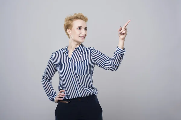 Blonde businesswoman pointing at copy space — Stock Photo, Image