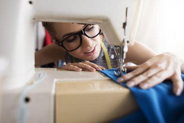 Young tailor working with sewing machine  clipart
