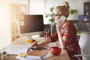 Kadın cep telefonuyla konuşuyor. 