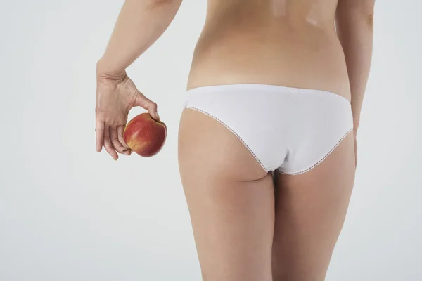 Frauengesäß und Apfel in der Hand — Stockfoto