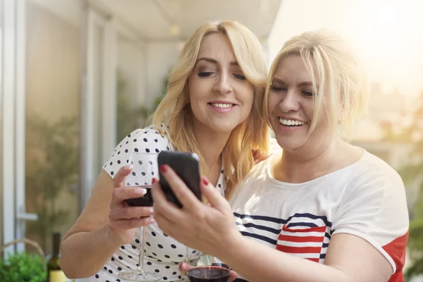 Mujeres hojeando fotos en el balcón —  Fotos de Stock