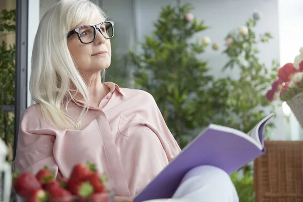 Frau liest Buch auf Balkon — Stockfoto