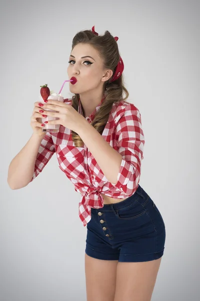 Pin up meisje met milkshake en grote aardbei — Stockfoto