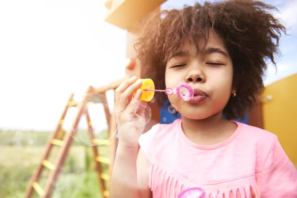 Girl blowing soap bubbles — Stock Photo, Image