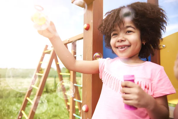 African girl blowing soap bubbles — Stock Photo, Image