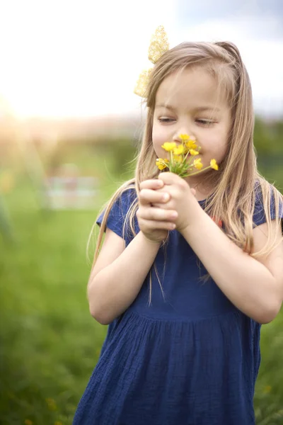 Malá holčička vonící kytice — Stock fotografie