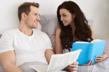 Birkaç kitap ve gazete yatakta okuma 