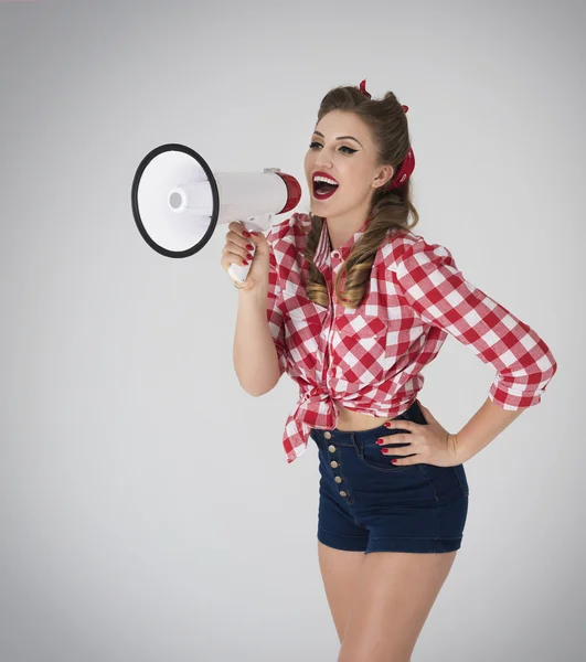 Pin up girl shouting through megaphone — Stock Photo, Image