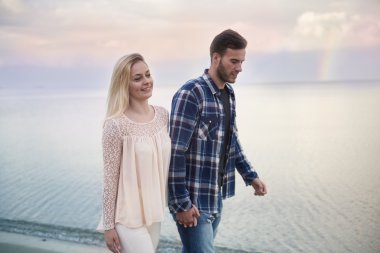 Kumsalda yürüyen çift.