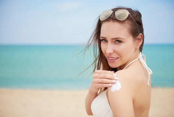 Vrouw toepassen van zon crème op schouders — Stockfoto