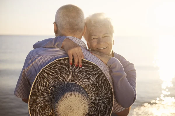 Senior couple hugging by the sea