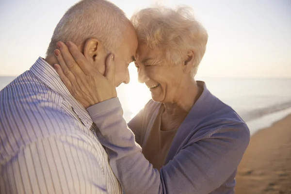 Couple aîné étreignant sur la plage — Photo