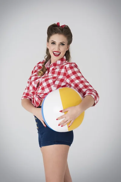 Pin up menina segurando bola de praia — Fotografia de Stock