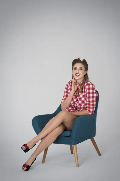 Pin up girl resting in blue armchair — Stock Photo, Image