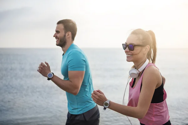 Coppia jogging insieme sulla spiaggia — Foto Stock