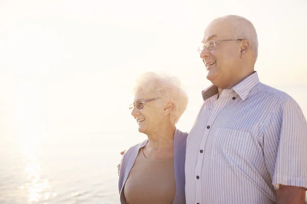 Seniorenpaar wandelen op het strand — Stockfoto